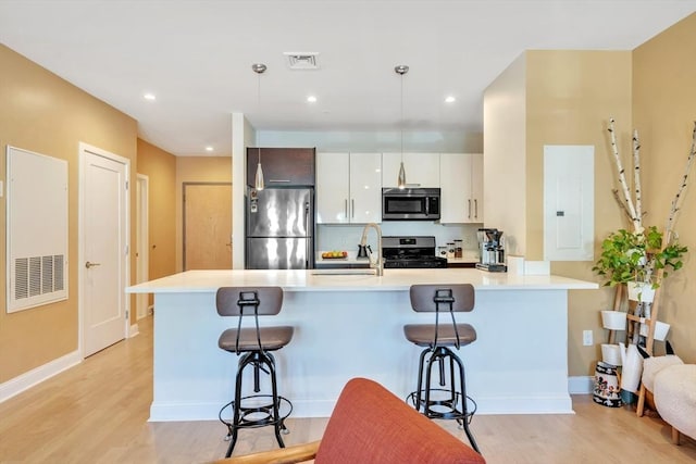 1 Brook Rd Unit 215, Quincy, MA 02169 - kitchen with appliances with stainless steel finishes, electric panel, a breakfast bar area, light wood-style flooring, and recessed lighting