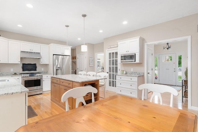 12 Cranberry Ln, Wrentham, MA 02093 - kitchen with stainless steel appliances, under cabinet range hood, a kitchen island, recessed lighting, and light wood-type flooring