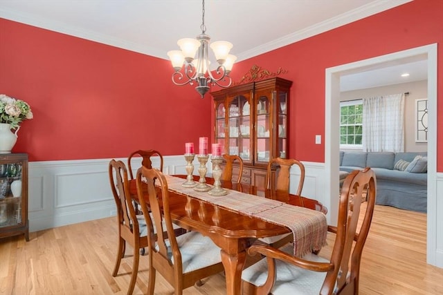 12 Cranberry Ln, Wrentham, MA 02093 - dining area with a chandelier, light wood finished floors, a wainscoted wall, ornamental molding, and a decorative wall