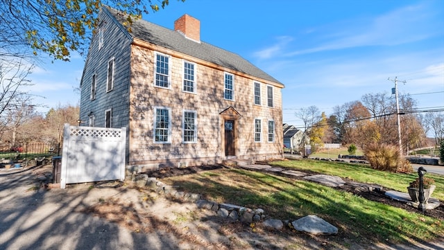 colonial inspired home with a front lawn