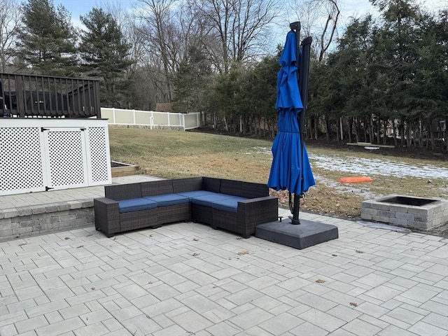 view of patio featuring an outdoor living space with a fire pit and fence