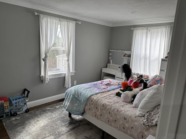 bedroom with baseboards, ornamental molding, and wood finished floors