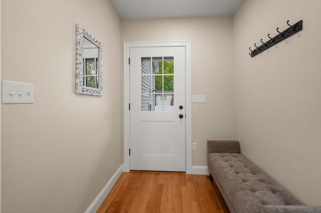 doorway featuring light wood-style flooring and baseboards