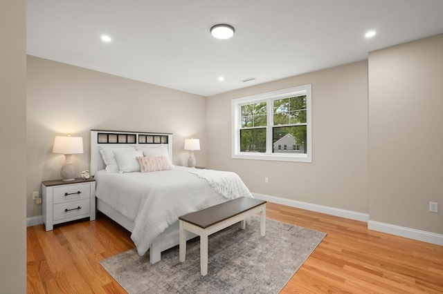 bedroom featuring baseboards, light wood-style flooring, and recessed lighting