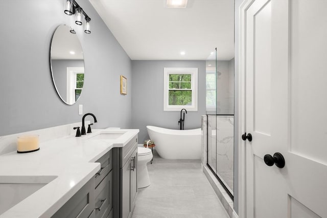 bathroom with a freestanding bath, vanity, a shower, and recessed lighting