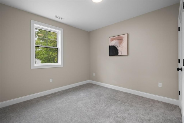 carpeted spare room featuring baseboards