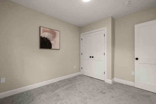 unfurnished bedroom with carpet, baseboards, and a closet