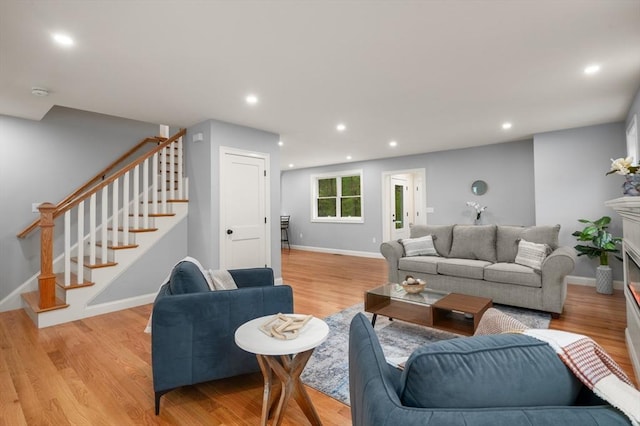 living room featuring stairway, light wood-style flooring, recessed lighting, and baseboards