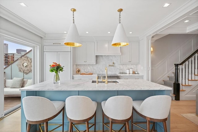 8 Union Wharf Unit 8, Boston, MA 02109 - kitchen with decorative backsplash, a sink, light stone counters, an island with sink, and decorative light fixtures