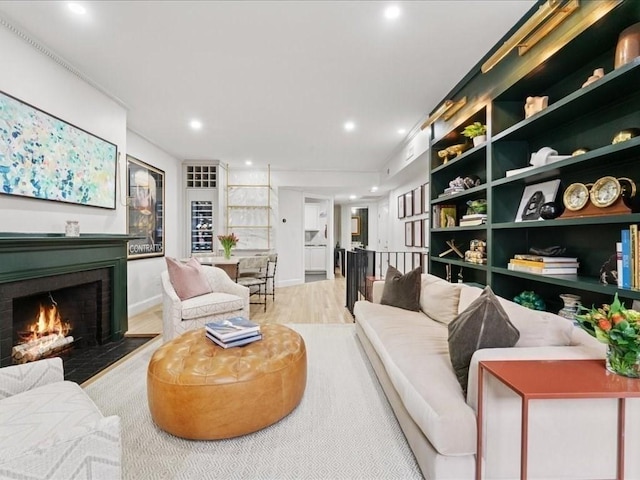 living area featuring a fireplace, built in features, wood finished floors, and recessed lighting