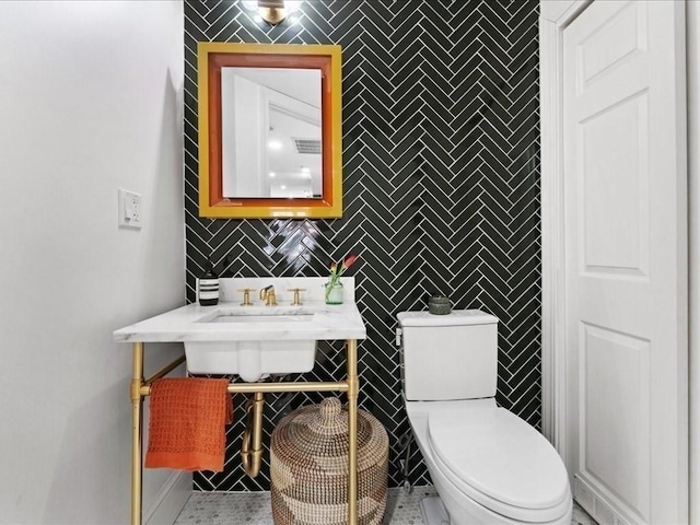 bathroom with visible vents, tile walls, and toilet