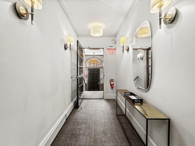 hall with baseboards, dark colored carpet, and crown molding