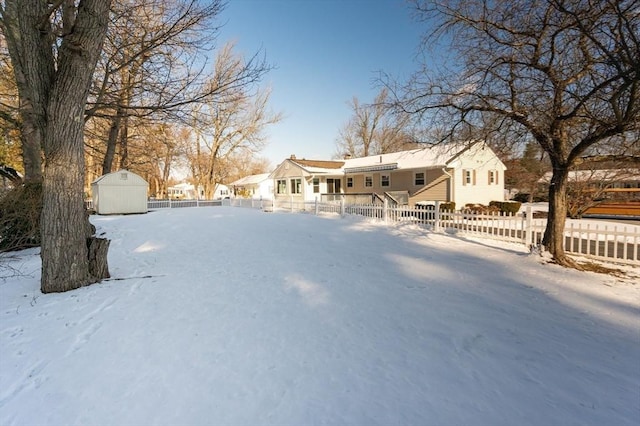 snowy yard featuring a shed