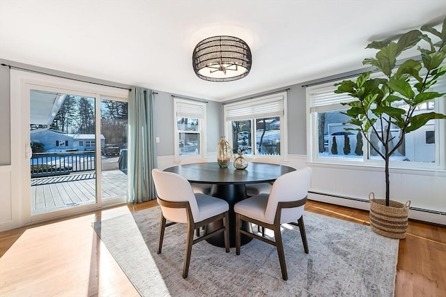 dining space with hardwood / wood-style flooring and a baseboard radiator