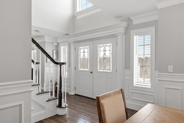 entryway featuring stairs, ornamental molding, plenty of natural light, and dark wood-style floors