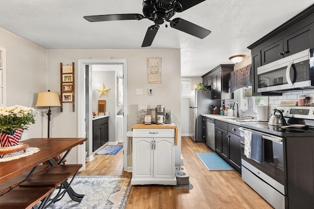 53 Avon St, Taunton, MA 02780 - kitchen featuring appliances with stainless steel finishes, a sink, light wood-type flooring, ceiling fan, and dark cabinetry