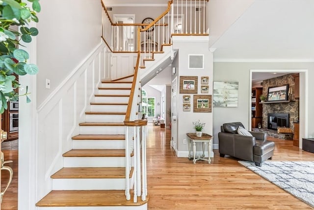 225 Walker St, Seekonk, MA 02771 - stairway with a stone fireplace, wood finished floors, ornamental molding, and a towering ceiling
