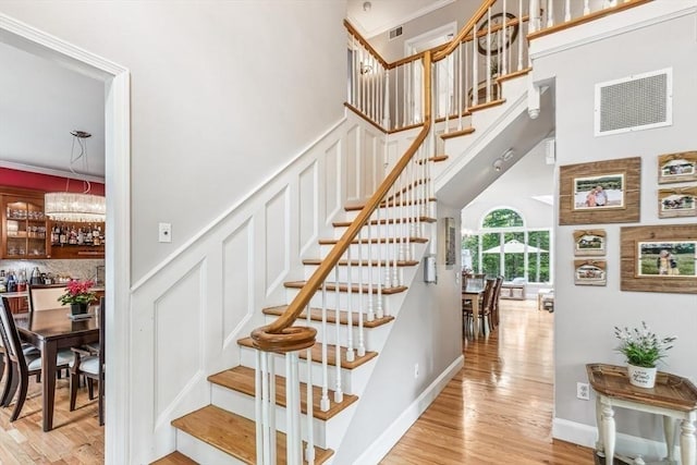 225 Walker St, Seekonk, MA 02771 - staircase with wood finished floors, crown molding, a high ceiling, and a decorative wall