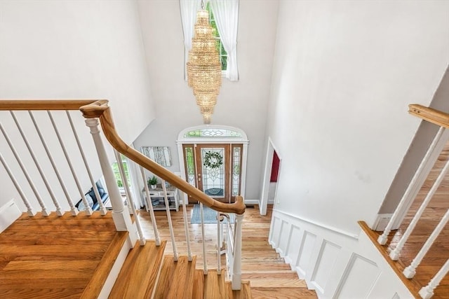 225 Walker St, Seekonk, MA 02771 - foyer with light wood-style flooring, a high ceiling, a wainscoted wall, stairs, and a chandelier