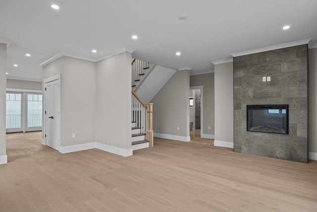 unfurnished living room featuring crown molding, a tile fireplace, and light hardwood / wood-style flooring