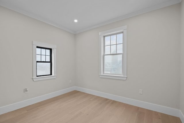 empty room with light hardwood / wood-style flooring and crown molding