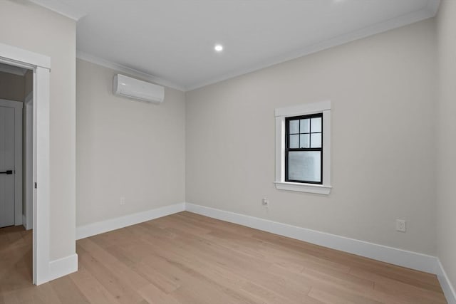 unfurnished room with an AC wall unit, light hardwood / wood-style flooring, and ornamental molding