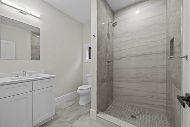 bathroom with tile patterned floors, vanity, toilet, and tiled shower