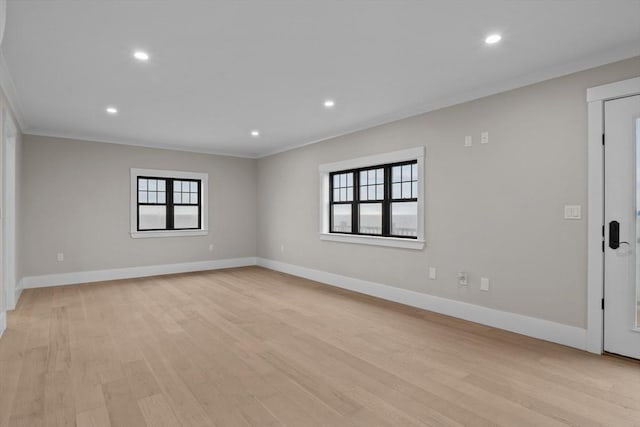 spare room featuring crown molding, light hardwood / wood-style flooring, and a healthy amount of sunlight