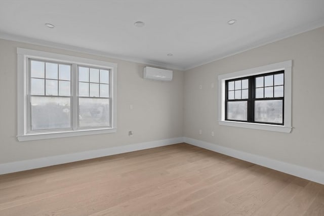 empty room featuring crown molding, plenty of natural light, light hardwood / wood-style floors, and a wall mounted air conditioner