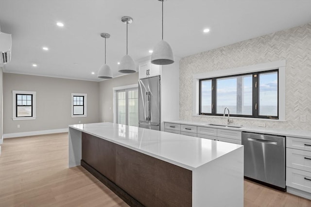 kitchen with a wealth of natural light, stainless steel appliances, hanging light fixtures, and sink