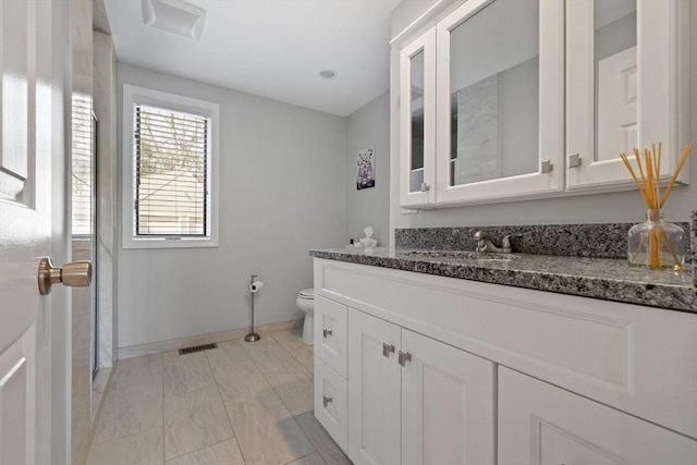 bathroom with visible vents, toilet, vanity, and baseboards