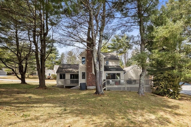 back of house featuring a yard, central air condition unit, a chimney, and a deck