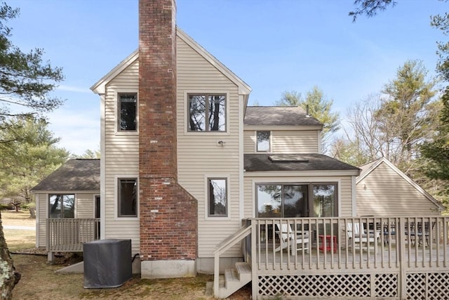 back of property featuring a deck and roof with shingles