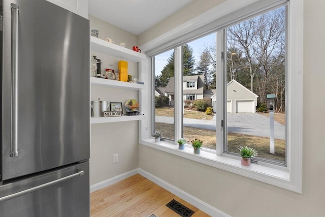 interior space featuring light wood finished floors, visible vents, and baseboards