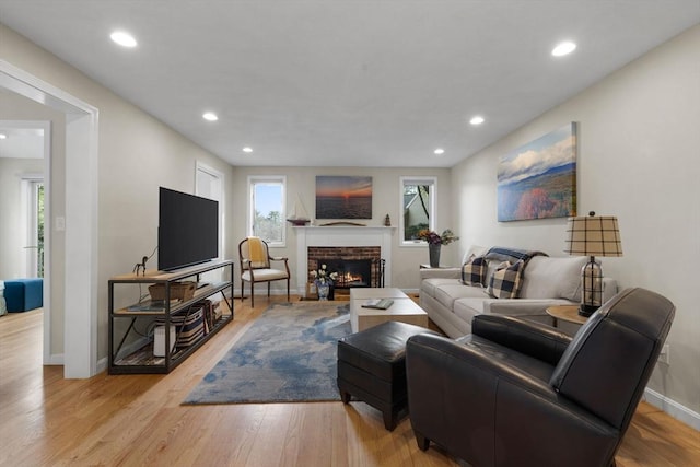 living area featuring a fireplace, recessed lighting, wood finished floors, and baseboards