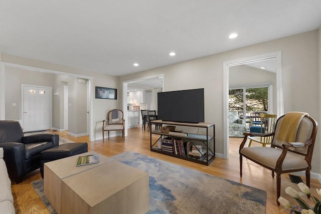 living area featuring recessed lighting, light wood-type flooring, and baseboards