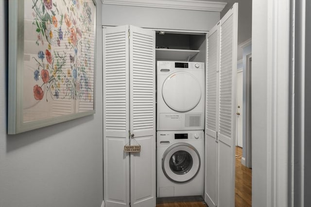 clothes washing area with stacked washer and clothes dryer, dark wood-type flooring, and crown molding