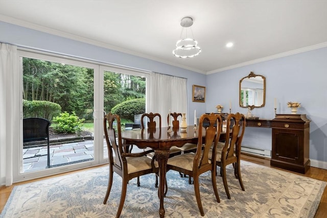 dining area with a baseboard heating unit, crown molding, light wood-type flooring, a chandelier, and baseboards