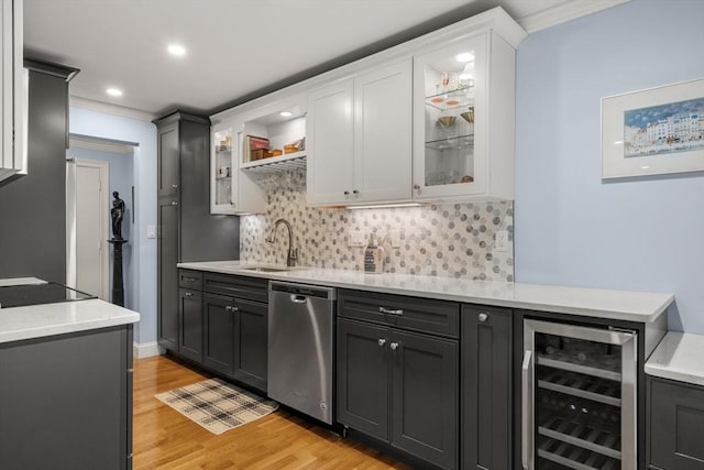 indoor wet bar featuring wine cooler, stainless steel dishwasher, light wood-style floors, backsplash, and recessed lighting