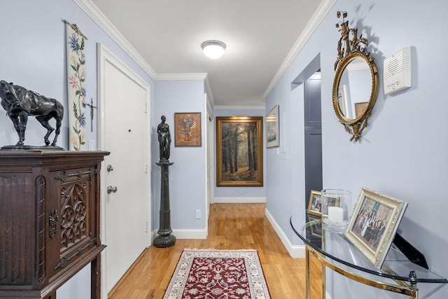 corridor featuring light wood-style flooring, crown molding, and baseboards