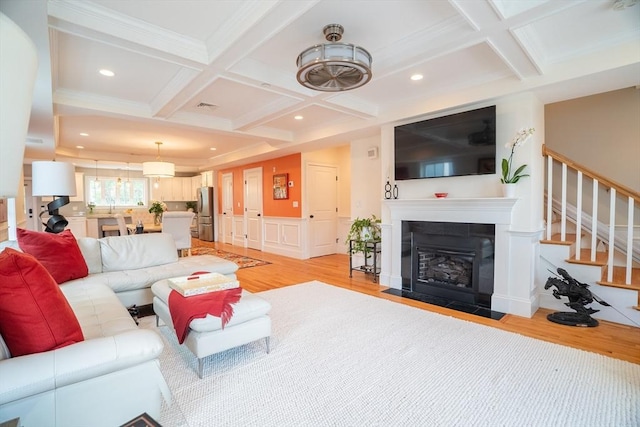 41 Washington Unit C, Newburyport, MA 01950 - living room with light wood finished floors, coffered ceiling, stairs, crown molding, and a fireplace with flush hearth