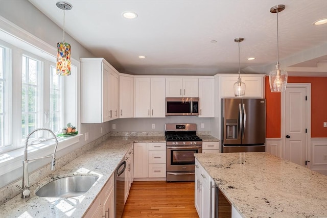41 Washington Unit C, Newburyport, MA 01950 - kitchen featuring appliances with stainless steel finishes, a sink, white cabinets, recessed lighting, and light stone countertops