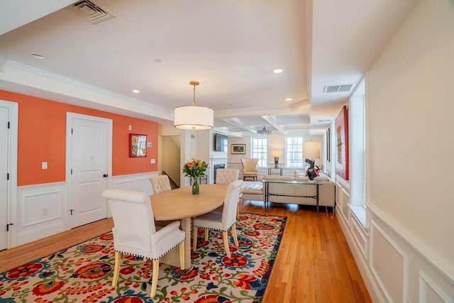 41 Washington Unit C, Newburyport, MA 01950 - dining space featuring light wood-style floors, a wainscoted wall, a decorative wall, recessed lighting, and crown molding