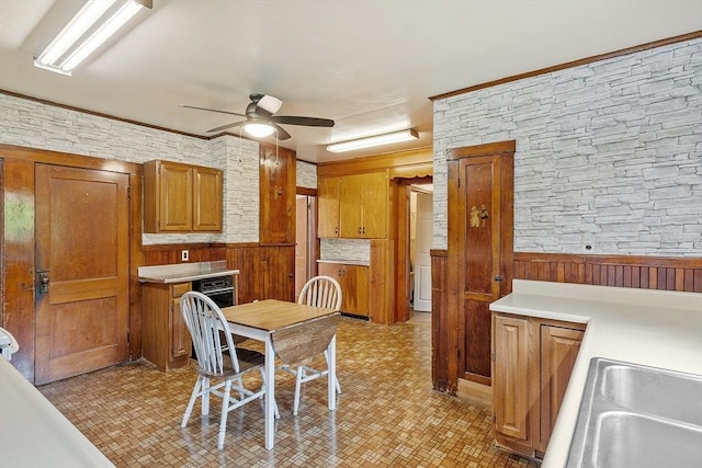 128 Arthur Ave, Athol, MA 01331 - kitchen with ceiling fan, brown cabinetry, light countertops, wood walls, and light flooring