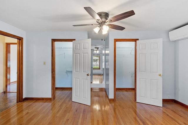 128 Arthur Ave, Athol, MA 01331 - unfurnished bedroom with a spacious closet, an AC wall unit, light wood-style floors, and baseboards