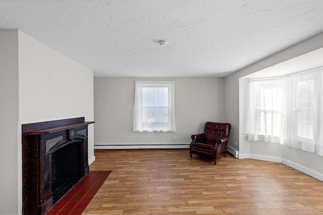 unfurnished room with hardwood / wood-style floors and a baseboard radiator