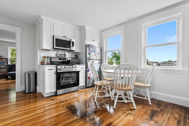 11 Barr St, Salem, MA 01970 - kitchen with stainless steel appliances, white cabinetry, light wood-type flooring, and tasteful backsplash