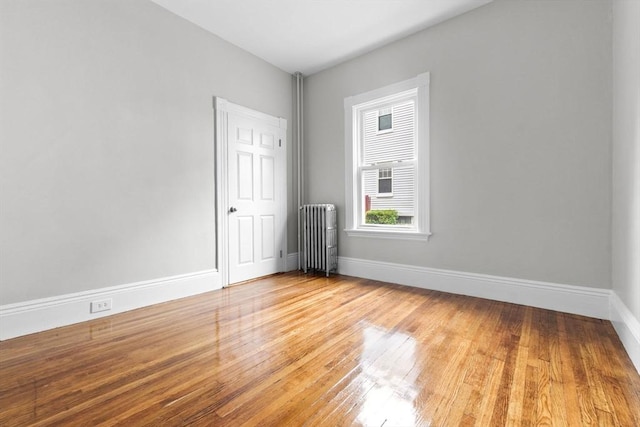 11 Barr St, Salem, MA 01970 - spare room with radiator heating unit and wood finished floors