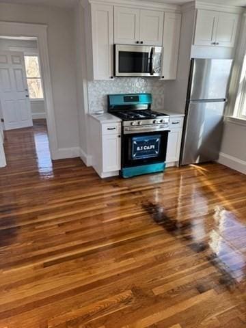 11 Barr St, Salem, MA 01970 - kitchen featuring stainless steel appliances, wood finished floors, light countertops, decorative backsplash, and white cabinetry