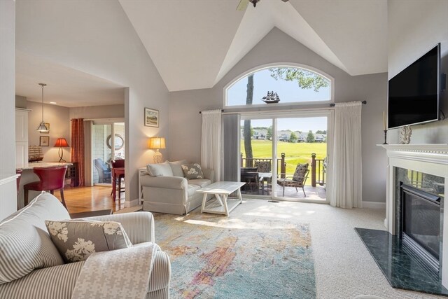 living room with carpet flooring, high vaulted ceiling, and a high end fireplace